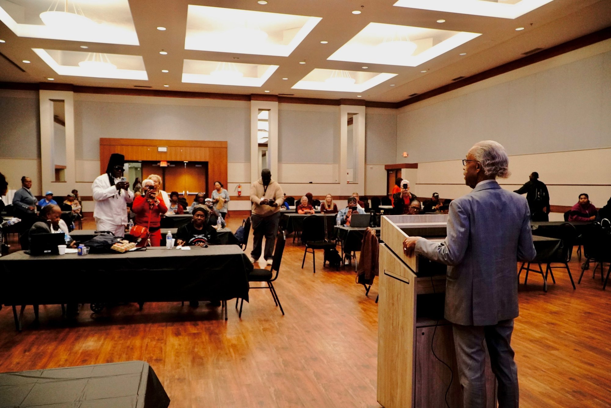 Rev. Al Sharpton addresses participants at their laptops in the Northwest Activities Center