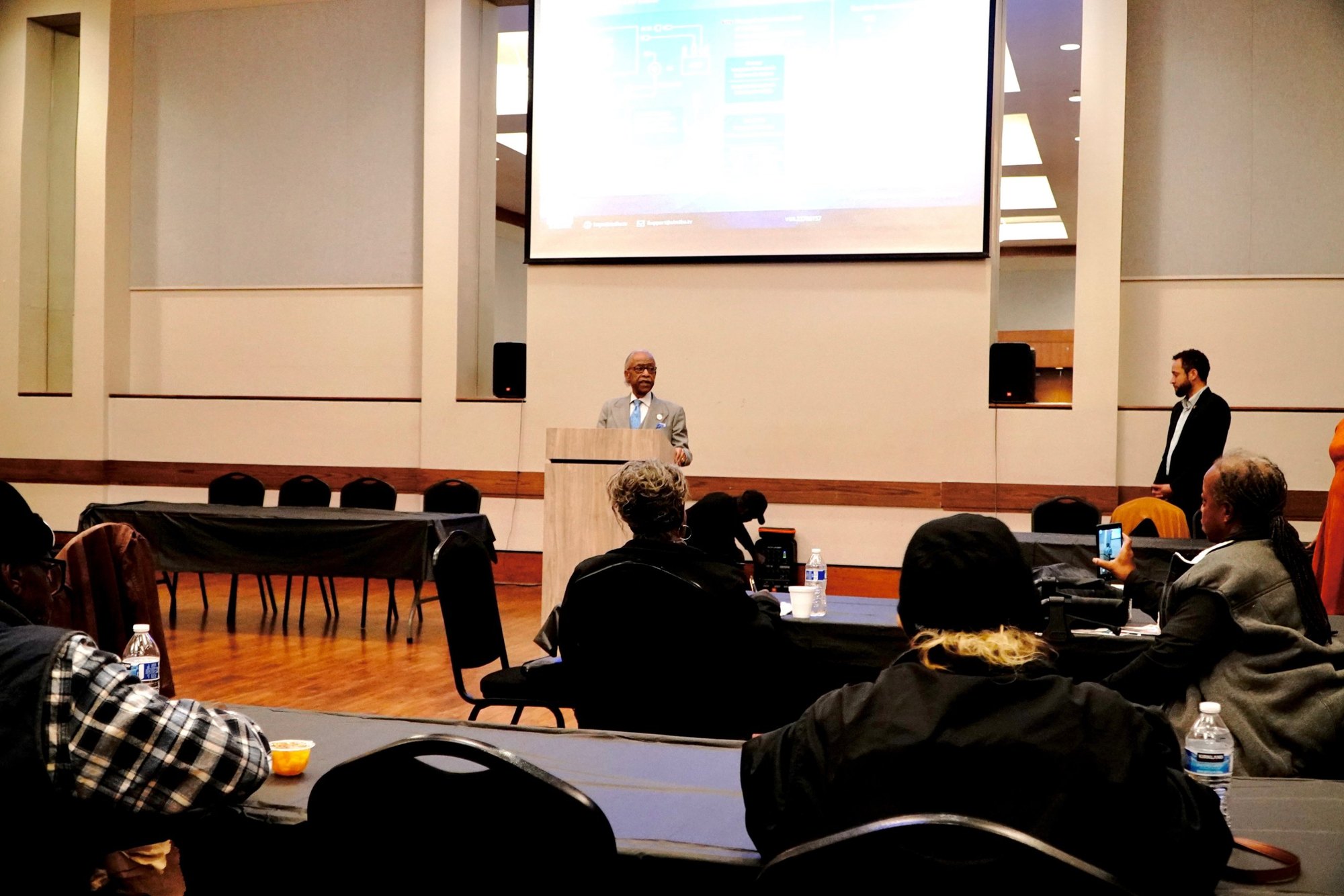 The room follows along on the big screen during the AI Fluency Workshop