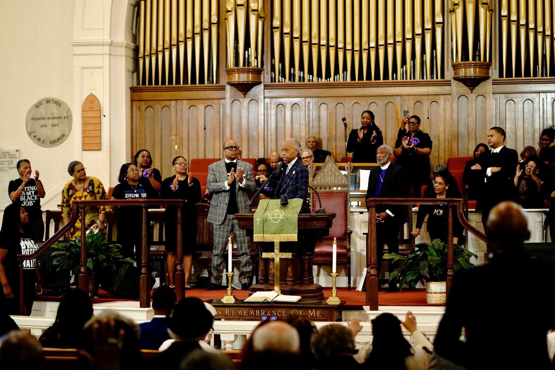 Rev. Al Sharpton at the Big Bethel pulpit with NAN Voter Brigade members in Voting Is My Black Job shirts standing behind him