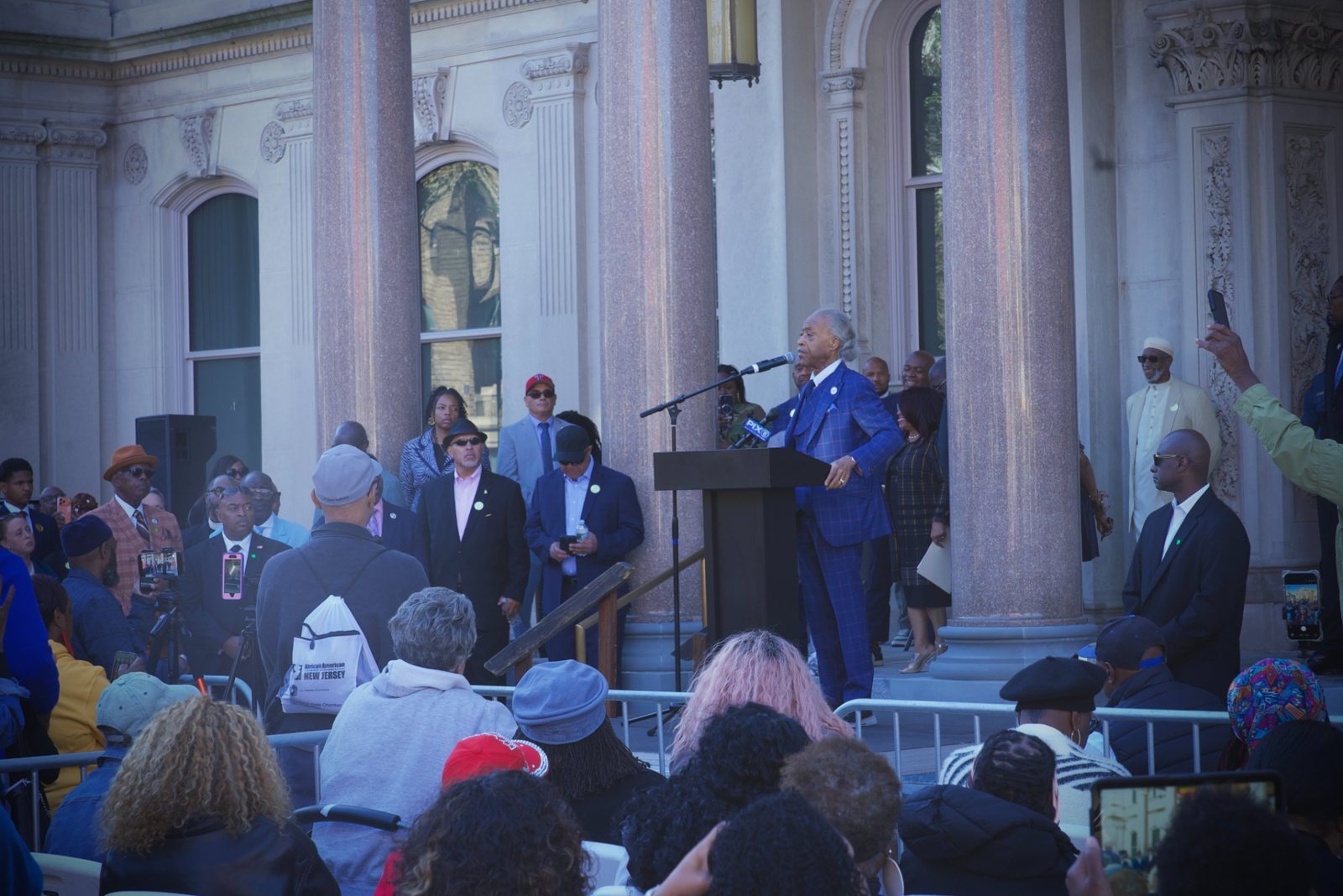 Rev. Al Sharpton speaks at the podium at the Black Agenda Rally at the State House
