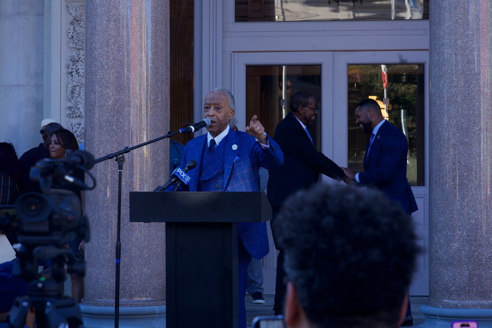 Rev. Al Sharpton speaks as leaders stand with him at the Black Agenda Rally