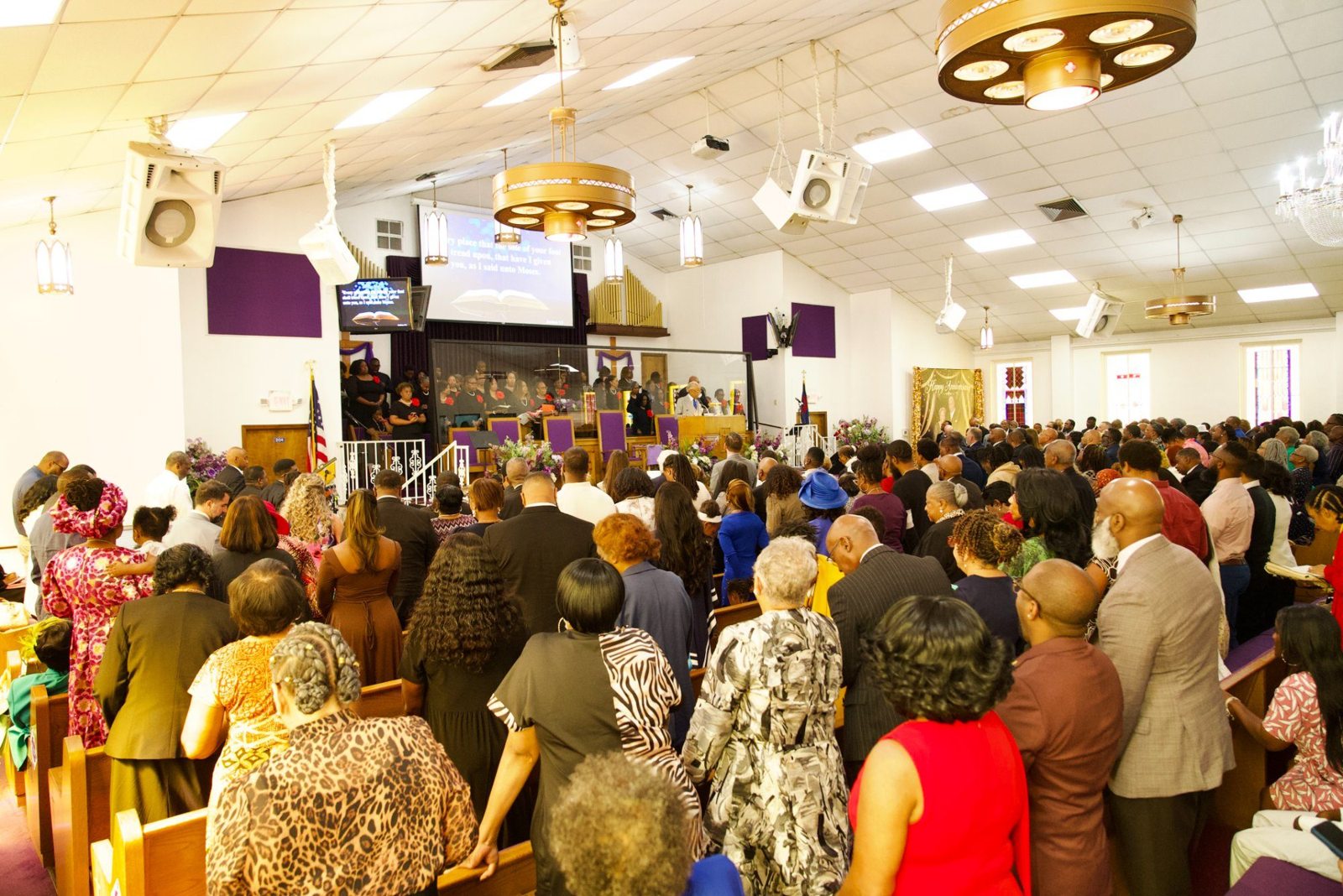 The congregation standing together in worship at the Bethel anniversary