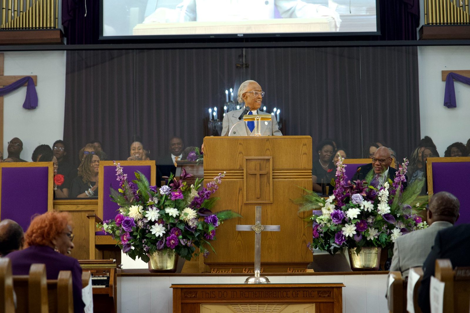 Rev. Al Sharpton preaching from the pulpit as Pastor R.B. Holmes Jr. is seated nearby