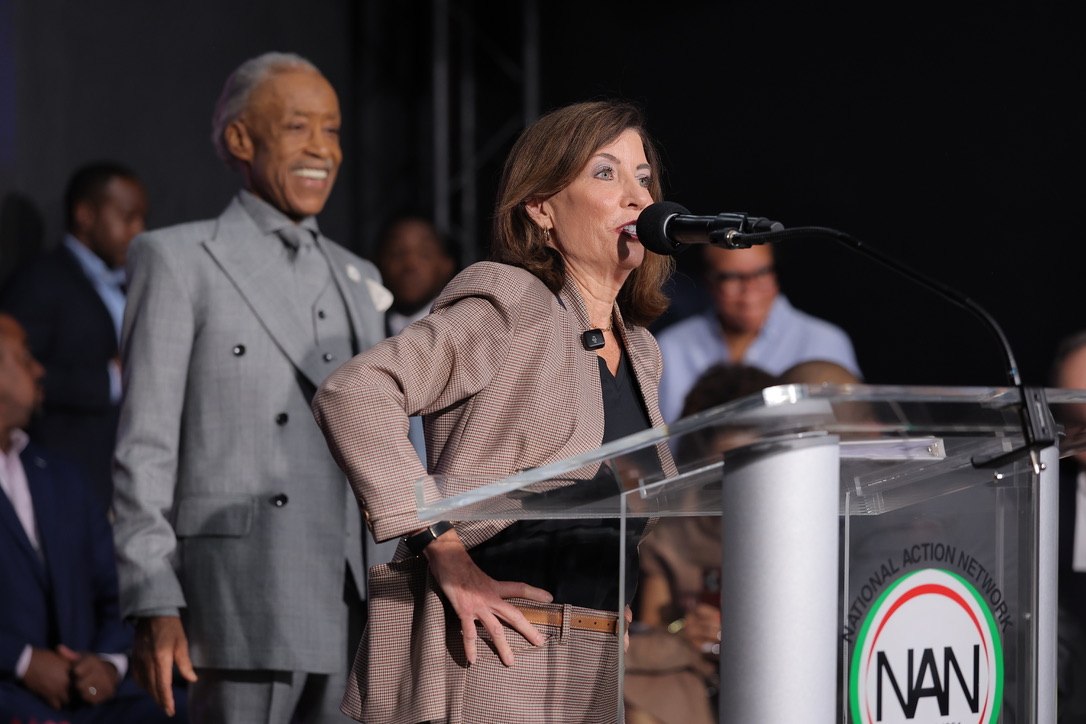 New York Governor Kathy Hochul addresses the House of Justice as Rev. Al Sharpton looks on