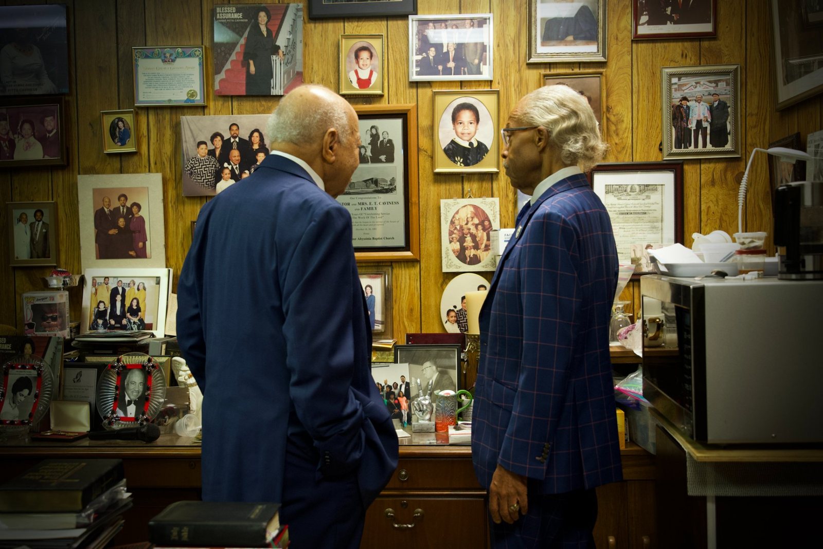 Rev. Al Sharpton and Bishop Caviness look over the wall of photographs chronicling decades of ministry and movement