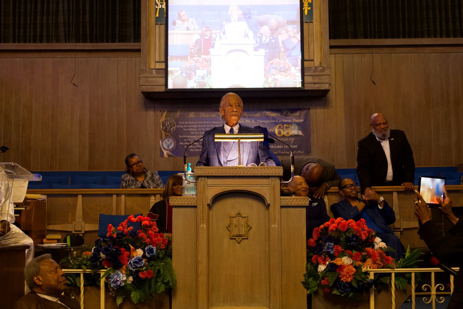 Rev. Al Sharpton addresses the congregation beneath the Pastoral 65th Anniversary banner at Greater Abyssinia Baptist Church