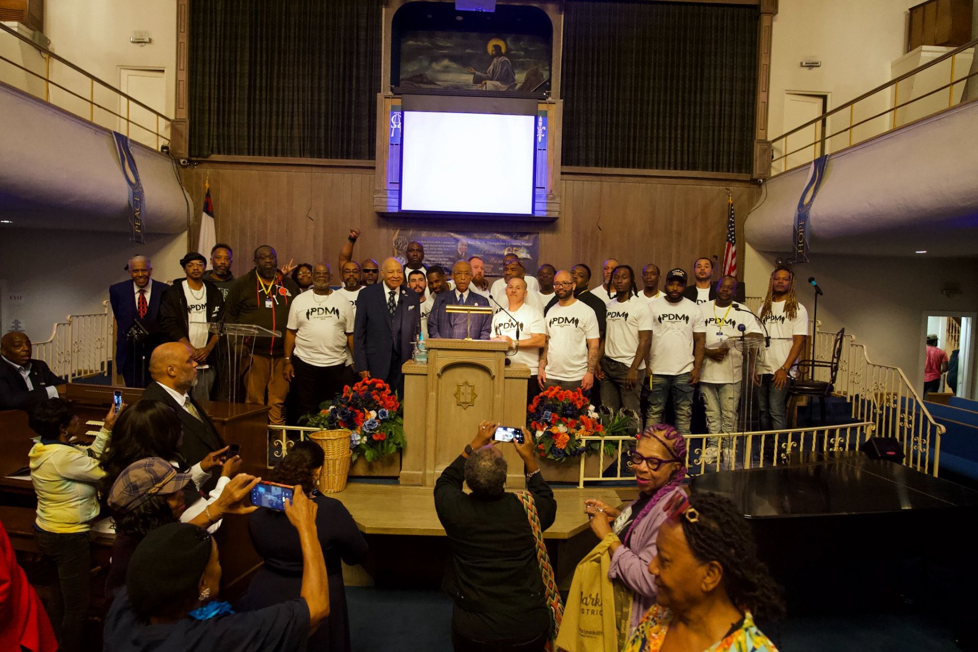 Rev. Al Sharpton, Bishop E. T. Caviness Sr., and community members and organizers gathered on the pulpit at Greater Abyssinia Baptist Church