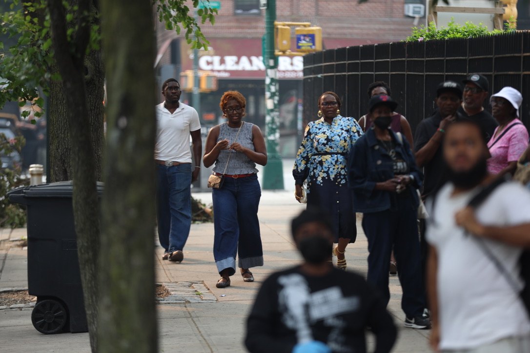 Community members walk the Harlem streets toward the new House of Justice