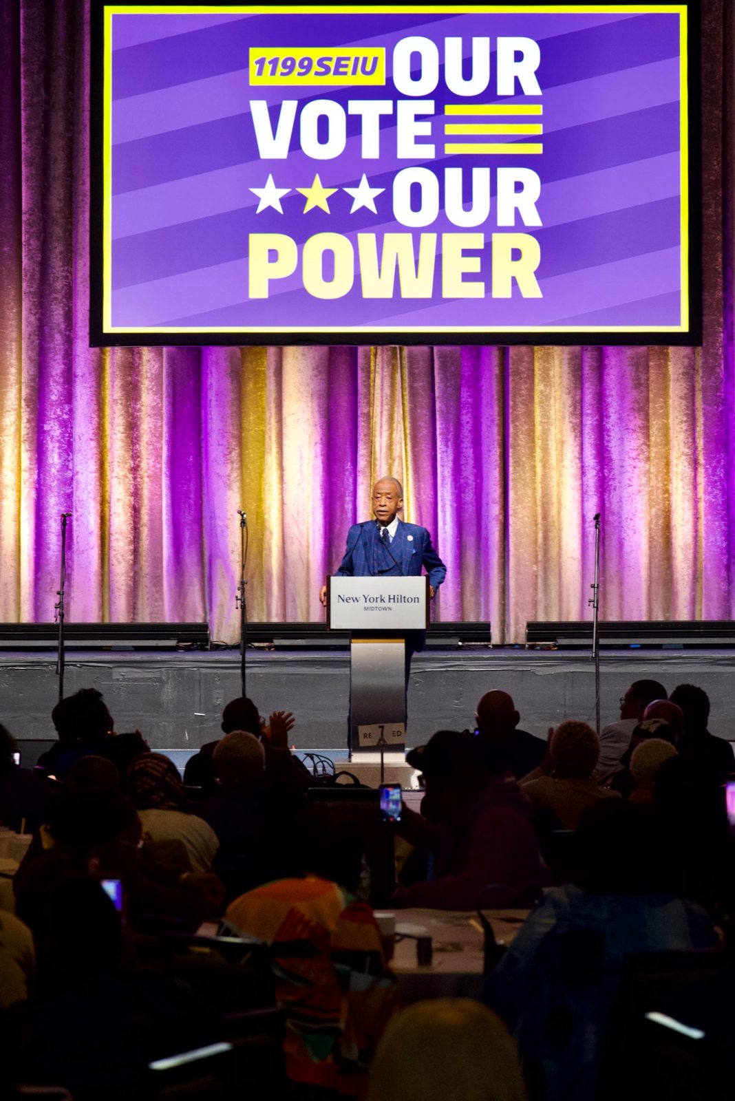 Rev. Al Sharpton speaks beneath the Our Vote, Our Power screen at the New York Hilton Midtown